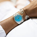 Oris Divers Sixty-Five Cotton Candy Unisex 01 733 7771 4055-07 8 19 18 horloge 38mm met turquoise wijzerplaat en roestvrijstalen band, gedragen om een pols. Luxe Swiss Made heren horloge voor dames en heren.