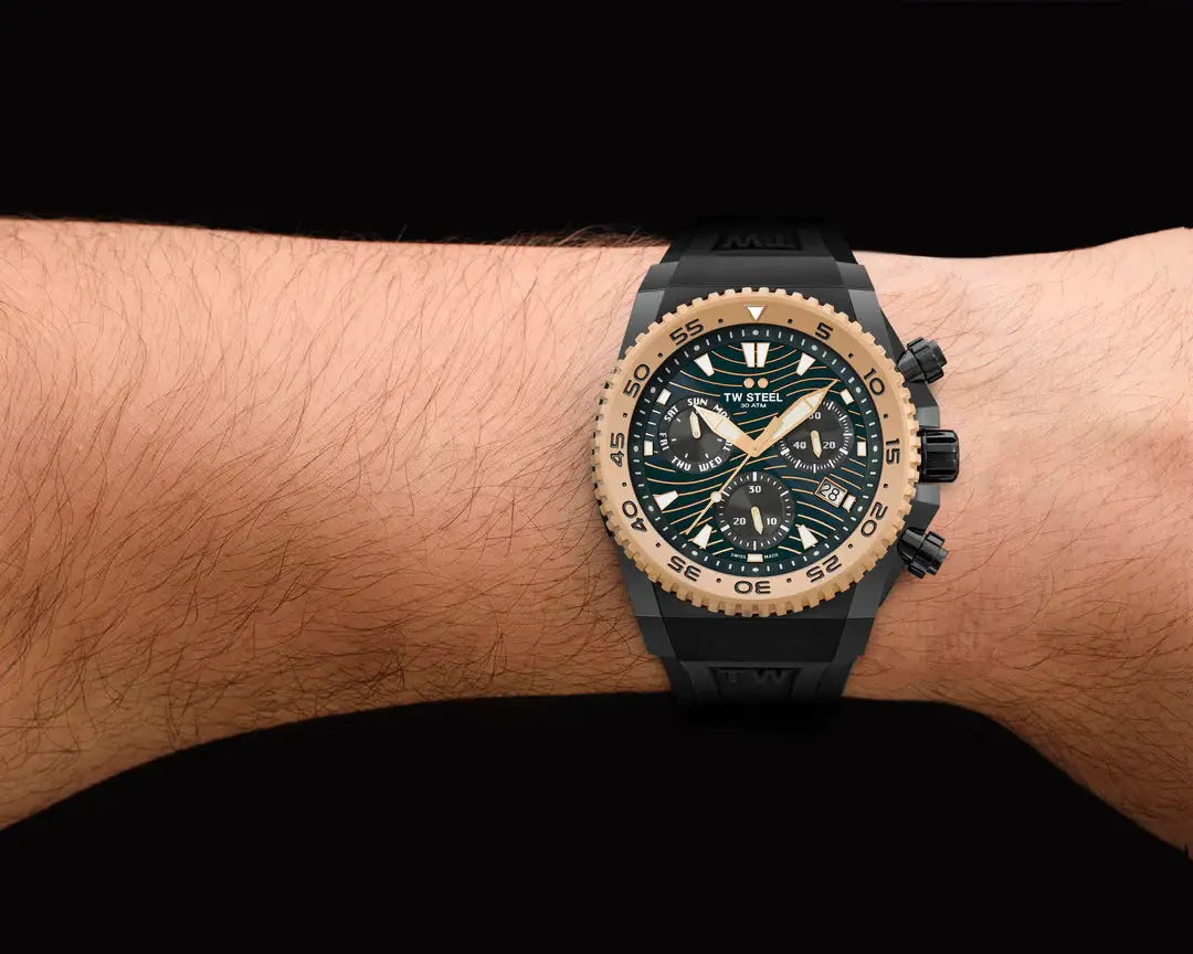 TW Steel Swiss Chronograaf Herenhorloge 44 mm met zwarte wijzerplaat en goudkleurige bezel, gedragen om een pols. Limited edition duikhorloge.