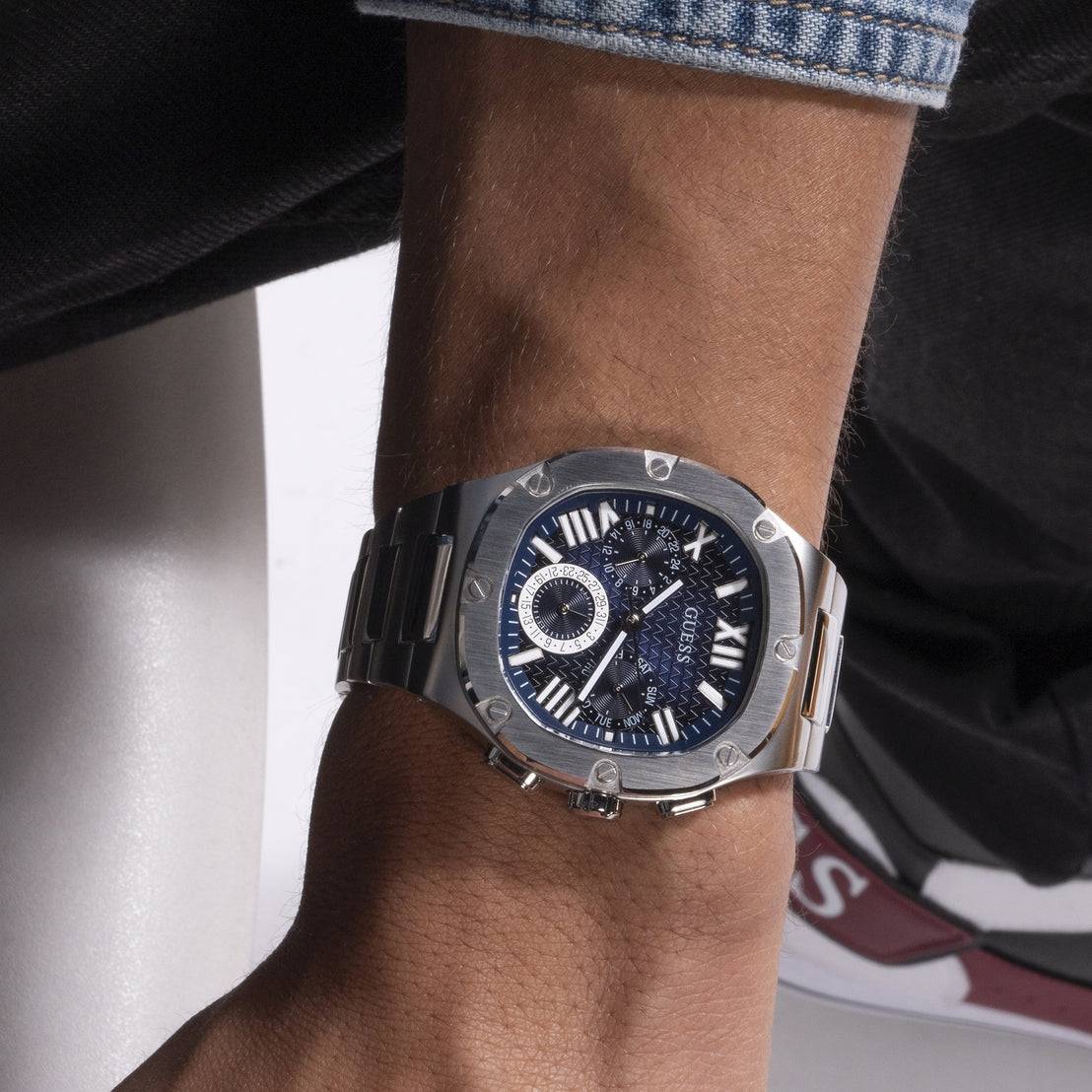 Guess Watches GW0572G1 Headline Herenhorloge 42mm met blauwe ombré wijzerplaat en roestvrijstalen band, gedragen om de pols. Luxe herenhorloge in moderne stijl.